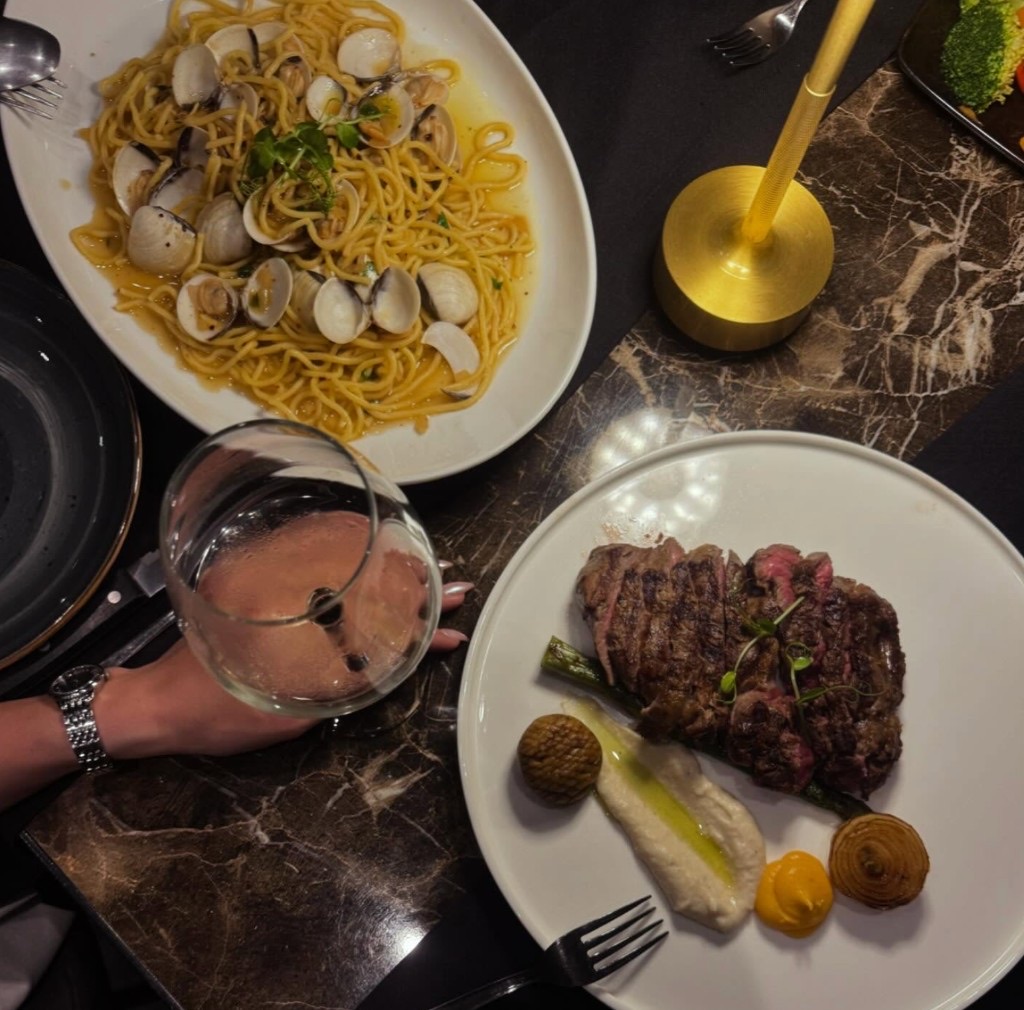 Evening table at Ficardo with steak, seafood pasta and wine